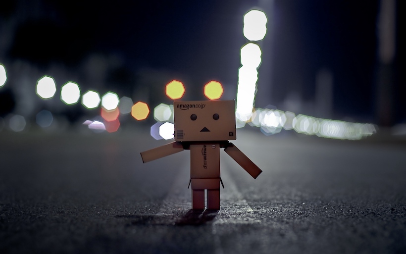 A figure made of Amazon boxes stands on a night time street. He represents what kind of people start online businesses
